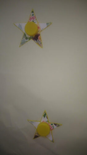 Estrela realizada com pacotes de sumo compal e tampinhas .