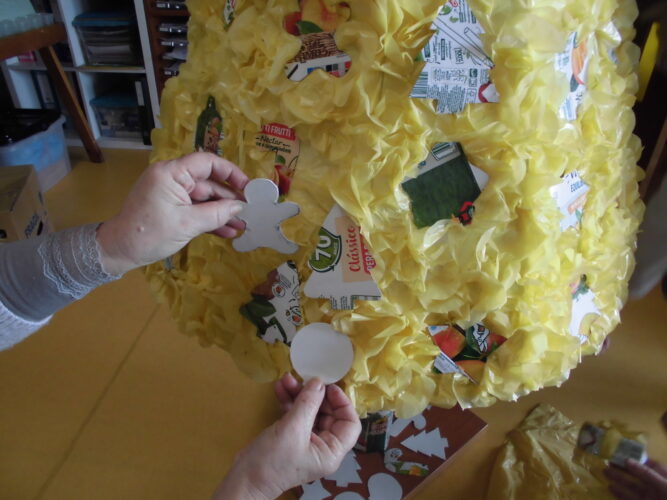Colagem dos círculos de plástico amarelo na estrutura da Árvore de Natal