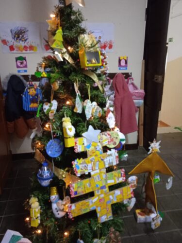 Arvore de natal amarela com a colaboração do país / família com materiais reciclados.